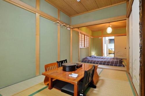 大阪市にあるGuest House TIHARU 6bedrooms12people max and Straight to USJ and Near the hot springのテーブルとベッドのあるリビングルーム