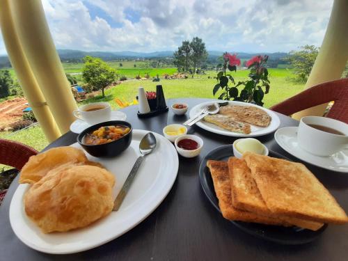 a table topped with plates of food and toast at The Arcadia Pool and Villa - Umroi in Shillong
