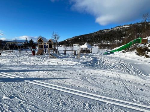 een met sneeuw bedekte helling met een speeltuin in de verte bij Vasethytta - cabin with a lovely view in Brujordet