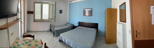 a small bedroom with a bed and a tv at Appartamento Vacanza Villetta Fichera in Gioiosa Marea