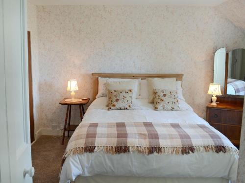 1 dormitorio con 1 cama grande y 2 lámparas en Old Midoxgate Farmhouse, en Calrossie