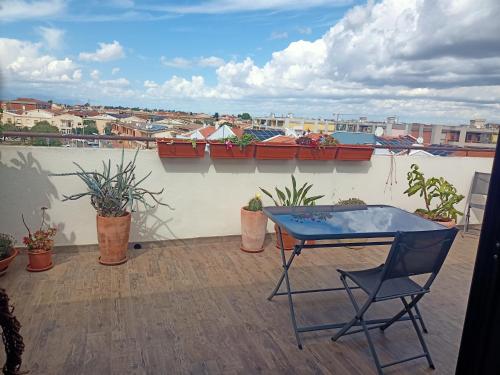 patio con tavolo e sedie sul tetto di Nice a Elmas