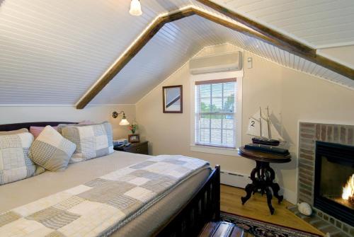 ein Schlafzimmer mit einem Bett und einem Kamin in der Unterkunft Revere Guest House in Provincetown