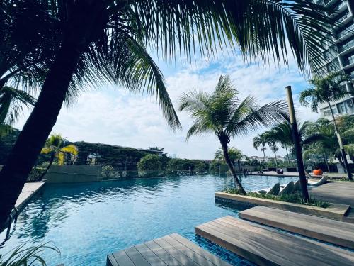 a swimming pool with palm trees in a resort at Kama Homestay @Wangsa Maju in Kuala Lumpur