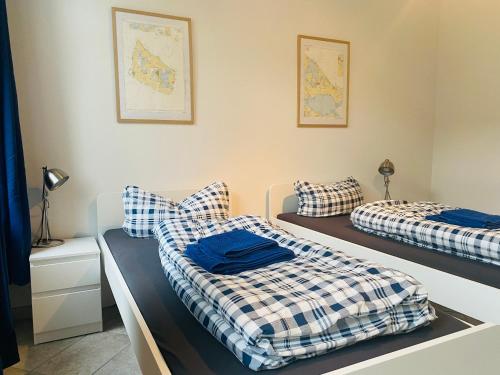 two beds in a room with blue and white sheets at Kapitänshaus an der Warnow mit Sauna in Rostock