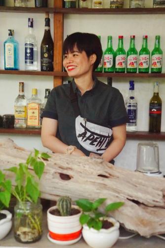 a man standing behind a counter in a room with bottles at Uyen's House in Con Dao