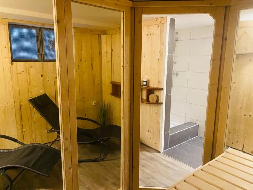 a room with wooden walls and a room with a chair at Kapitänshaus an der Warnow mit Sauna in Rostock