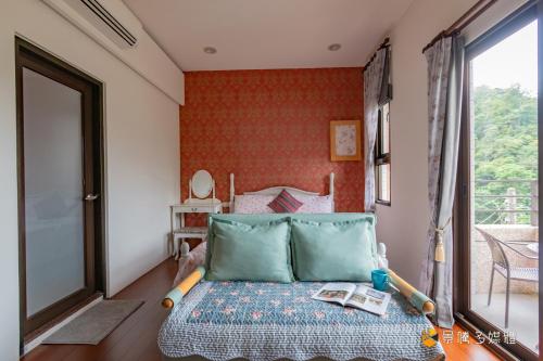 a small bedroom with a bed and a window at Atayal Villa in Datong