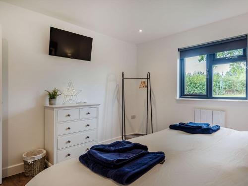 um quarto com uma cama com duas toalhas azuis em Bramley Lodge - Uk38384 em Lyonshall