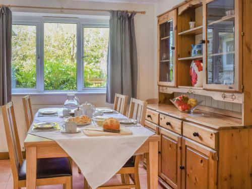 a kitchen with a table with a white table cloth on it at Gladys Orchard-uk38933 in Porthcurno