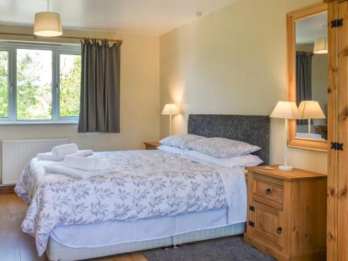 a bedroom with two beds and a mirror at Gladys Orchard-uk38933 in Porthcurno