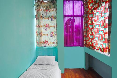 a blue room with a bed and two windows at Hotel O Rani Homestay Syariah in Jodoh