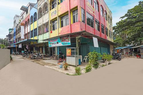 un edificio colorido con bicicletas estacionadas frente a él en SPOT ON 91732 Rani Homestay Syariah en Jodoh