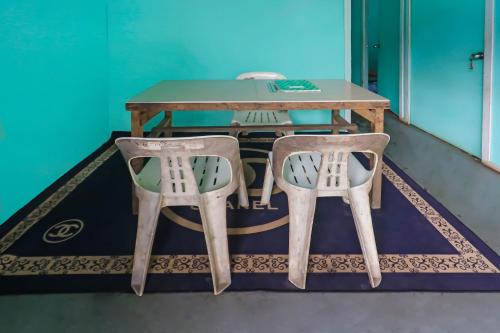 a table and two chairs in a room at Hotel O Rani Homestay Syariah in Jodoh