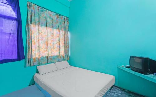 Dieses blaue Zimmer verfügt über ein Bett und einen TV. in der Unterkunft SPOT ON 91732 Rani Homestay Syariah in Jodoh