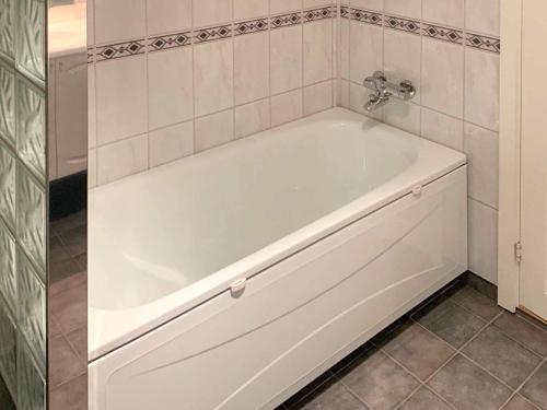 eine weiße Badewanne im Bad mit einer Kachelwand in der Unterkunft Holiday home Brekke in Brekke