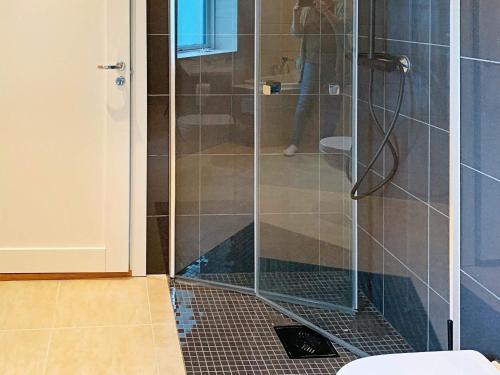 y baño con ducha y puerta de cristal. en Holiday home Bølandet 
