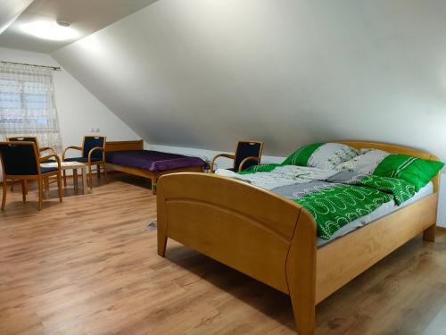 ein Zimmer mit einem Bett und Stühlen in der Unterkunft Gosciniec in Kodeń