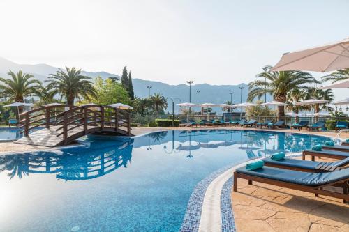 uma piscina num resort com cadeiras e guarda-sóis em Iberostar Bellevue All Inclusive em Budva