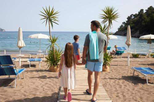 a man and a girl walking on the beach at Iberostar Bellevue All Inclusive in Budva