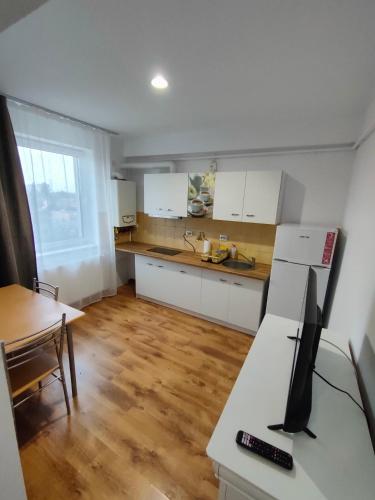 a kitchen with white cabinets and a desk with a computer at Fanea Residence in Timişoara