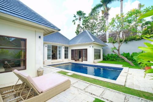 a villa with a swimming pool and a house at Casa Benita By Bracha Villas Management in Seminyak