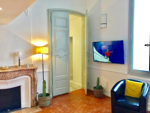 a living room with a fireplace and a tv at Les Suites du Cours & Spa in Aix-en-Provence