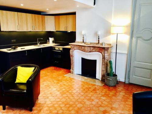 a kitchen with a fireplace and a chair in a room at Les Suites du Cours & Spa in Aix-en-Provence