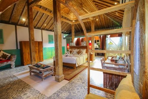 1 dormitorio con 1 cama y 1 mesa en una habitación en Kupu Kupu Jimbaran Beach Hotel & Spa by L’Occitane en Jimbaran