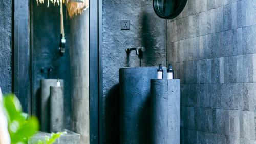 a bathroom with a shower with bottles of wine at ONAYA Bali Resort - Adults Only in Uluwatu