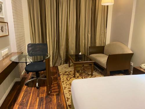 a hotel room with a bed and a chair and a table at Country Inn & Suites By Radisson Jammu in Jammu