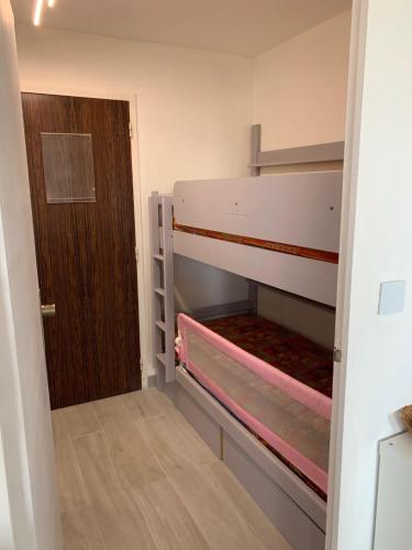 Cette chambre comprend 2 lits superposés et une porte. dans l'établissement Appartement 4 personnes vue mer, coeur de ville, au Grau-du-Roi