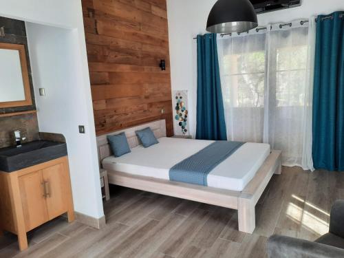 una camera da letto con letto e tende blu di Auberge du dom a Bormes-les-Mimosas