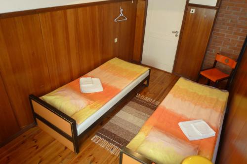 a small room with two beds and a chair at Kihelkonna Pastorate Guesthouse in Kihelkonna
