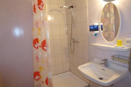 uma casa de banho com um chuveiro e um lavatório. em Kihelkonna Pastorate Guesthouse em Kihelkonna