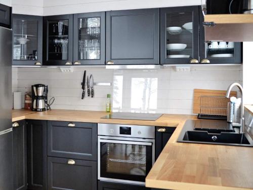 a kitchen with black cabinets and a sink at 10 person holiday home in S LEN in Stöten
