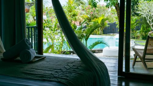 a hammock bed in a room with a view of a pool at ONAYA Bali Resort - Adults Only in Uluwatu