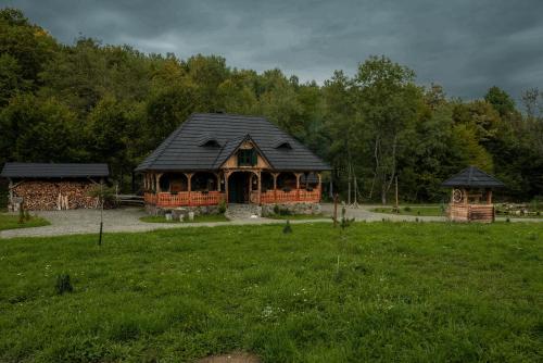 una cabaña de madera en medio de un campo en Huta Village, en Piatra