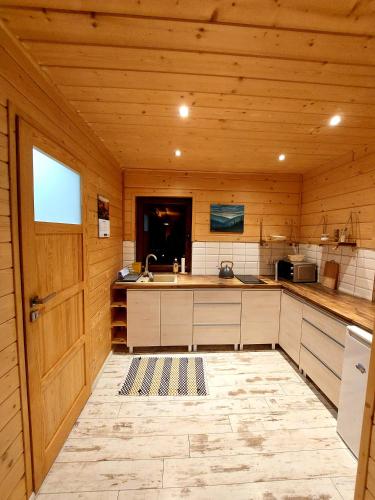a kitchen with wooden walls and a wooden door at Domki przy Młynie " Koło Młyńskie " in Krościenko