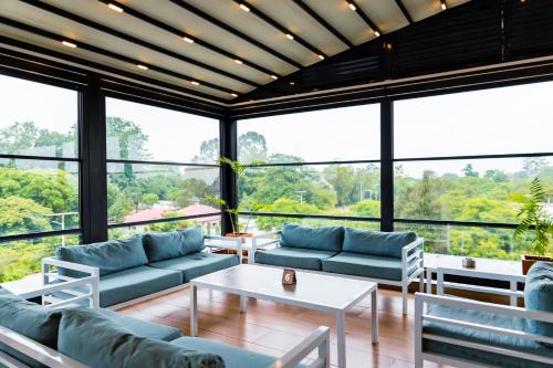 a living room with couches and a table and windows at The Quorum in Lusaka