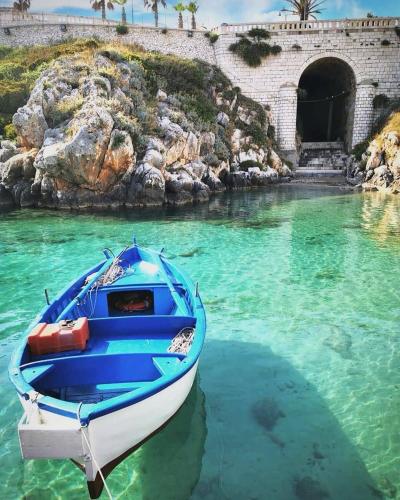 a blue boat in the water in front of a tunnel at Villaelena in Marittima