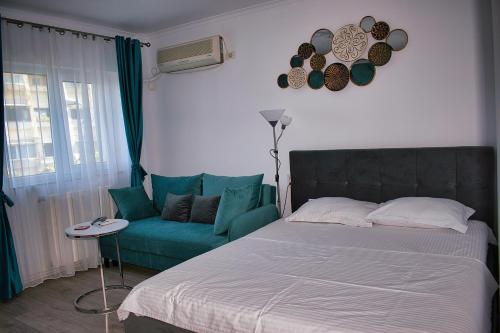 ein Schlafzimmer mit einem Bett und einem Sofa in der Unterkunft Sunrise by the Sea in Constanţa