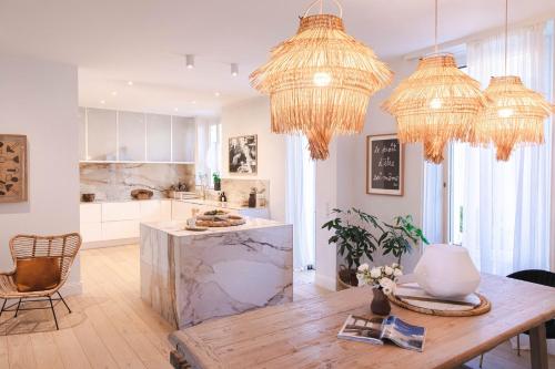 - une cuisine avec deux lustres et une table en bois dans l'établissement Appartement Design 5 stars Avec Terrasse Et Parking Cannes by Halldis, à Cannes