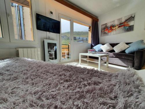 uma sala de estar com um grande tapete felpudo em SkiinSkiout Wifi Guardaesquís y Relax TETRAS em Pas de la Casa