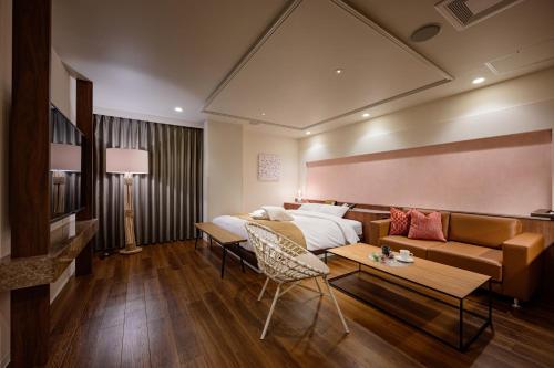 Habitación de hotel con cama y sofá en BAMBOO GARDEN 相模原, en Sagamihara