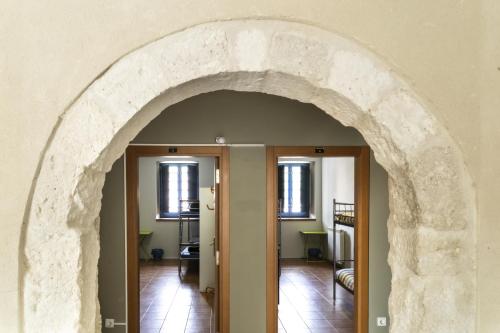 Un arco que conduce a una habitación con dos puertas en Albergue de Cuéllar, en Cuéllar