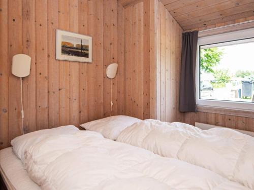 un lit dans une chambre avec un mur en bois dans l'établissement 12 person holiday home in Nordborg, à Nordborg