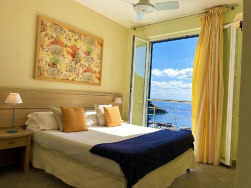 a bedroom with a bed with a view of the ocean at Residence Stella Marina in Ustica