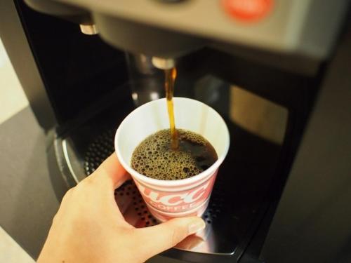 a person holding a cup of coffee in a espresso machine at Az Inn Fukui - Vacation STAY 65935v in Fukui