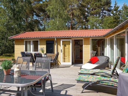 a house with a patio with a table and chairs at 6 person holiday home in Aakirkeby in Vester Sømarken
